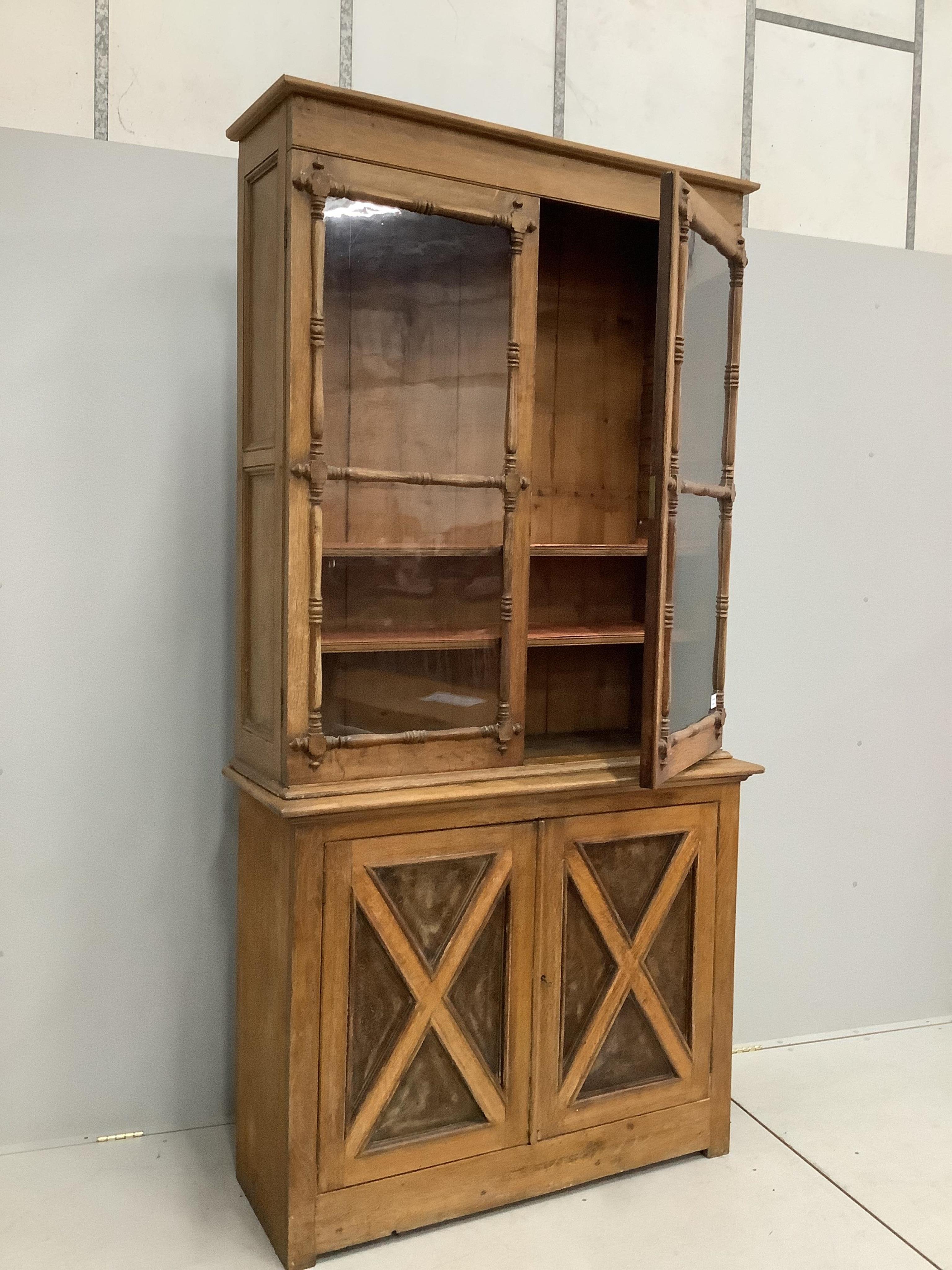 An early Victorian oak bookcase, width 120cm, height 232cm. Condition - some alterations and adaptions, fair